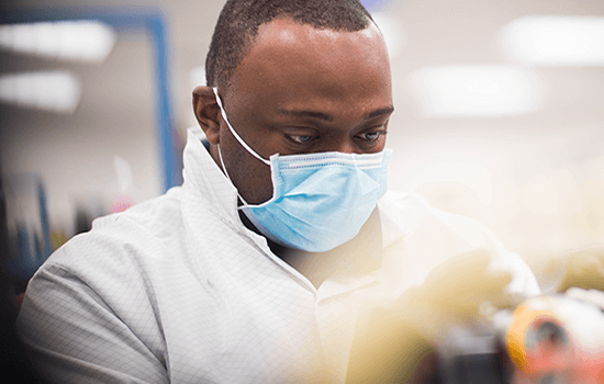 Mann med maske som arbeider på et laboratorium